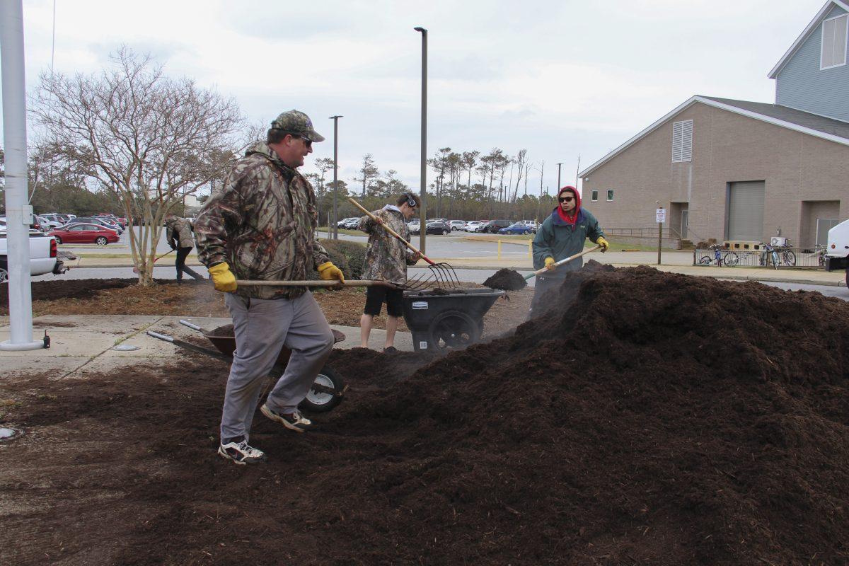 Joe Tyson works with students to add mulch to the front of the school. Photo by Payton Gaddy/Shorelines Yearbook
Special Education teacher Joe Tyson (left) shovels piles of mulch with students Noah Morgan (center) and Raejahn Greenley. Tyson and his students partnered with Earth Resources  -- a local landscaping company --to beautify the school before prom. 