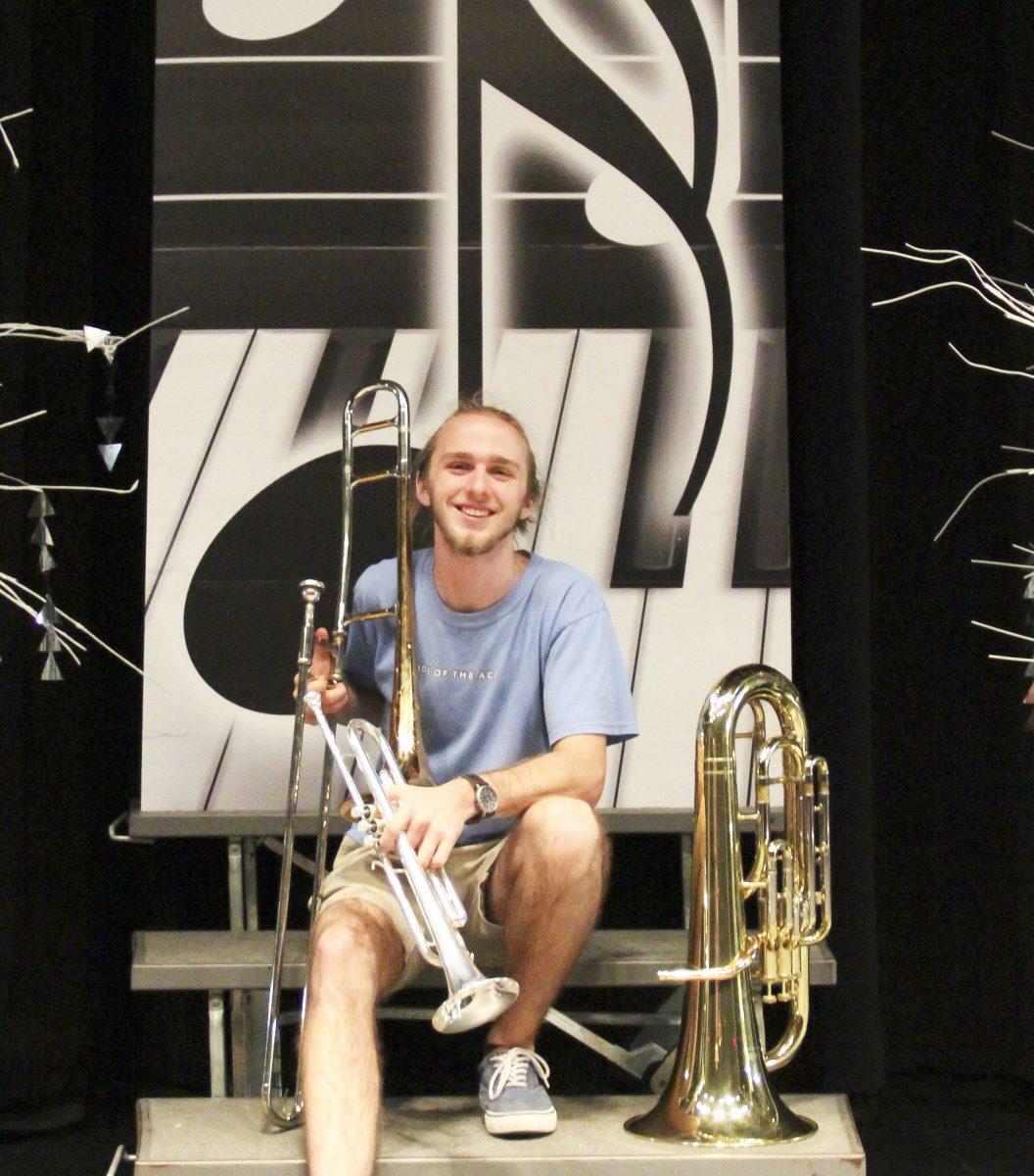 Senior Zane Fish poses with a handful of instruments that he has played throughout his high school career.