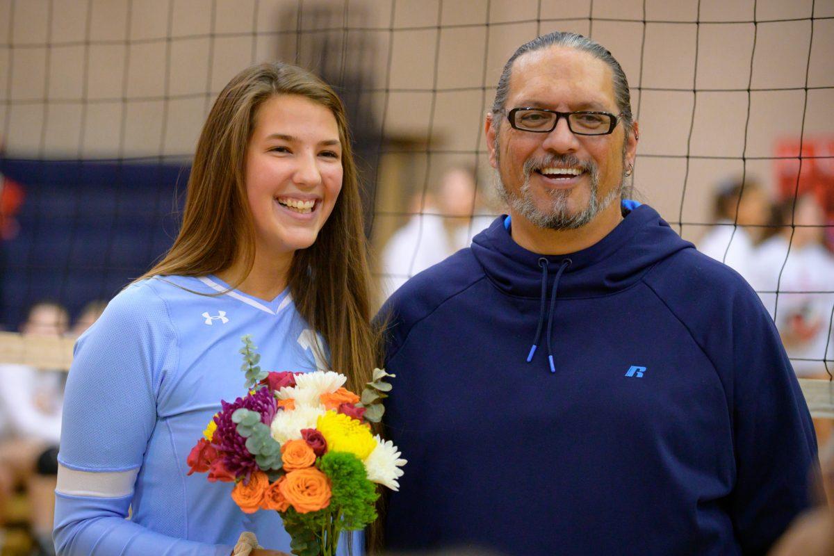 Senior Eliza Cowan (left) and coach Kevin Charles pose for a picture. PHOTO BY AARON JENNINGS/Special to Nighthawk News