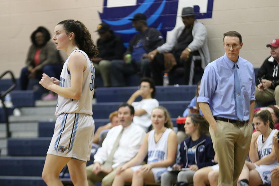 Sophomore Emma Richards watches the action unfold on the court during a game against Hickory (Va.) on Dec. 10 while her father – head coach Ray Richards – looks on from the sidelines. From soccer to softball to basketball, the duo has competed in countless games together. PHOTO BY TAYLOR NEWTON/Nighthawk News