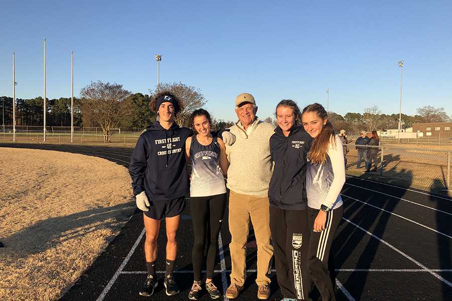 Track team members Aidan May, Maggie McNinch, Maddy Wagner and Madison Pugh enjoy a visit with their biggest fan, bus driver Tim Shearin. After driving cross country and track athletes to each race, Shearin exits the bus and cheers on every runner. PHOTO BY EMMA BYARD/Nighthawk News