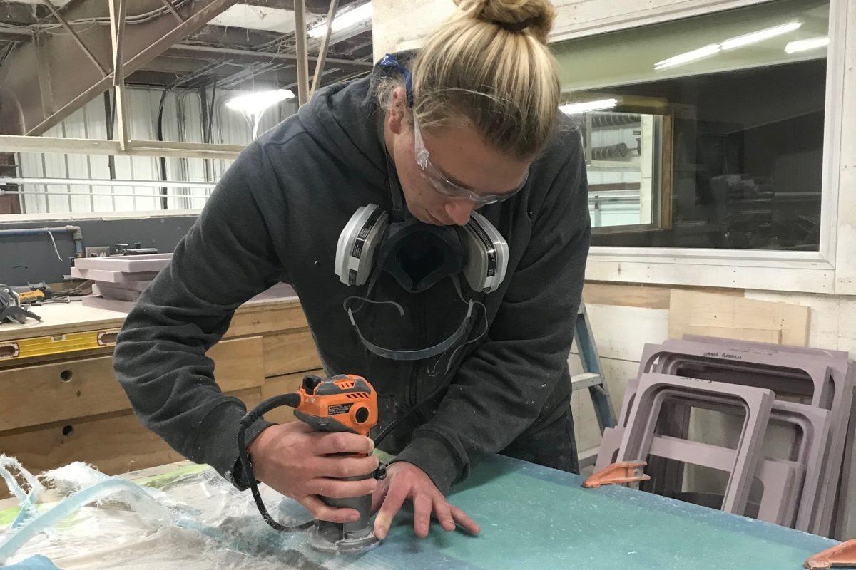Senior jack Clagett helps sand parts to be used on the products at Bayliss Boatworks. He gets to be fully immersed in the experience of the life of thew company. PHOTO BY KATHY NEAL/Special to Nighthawk News