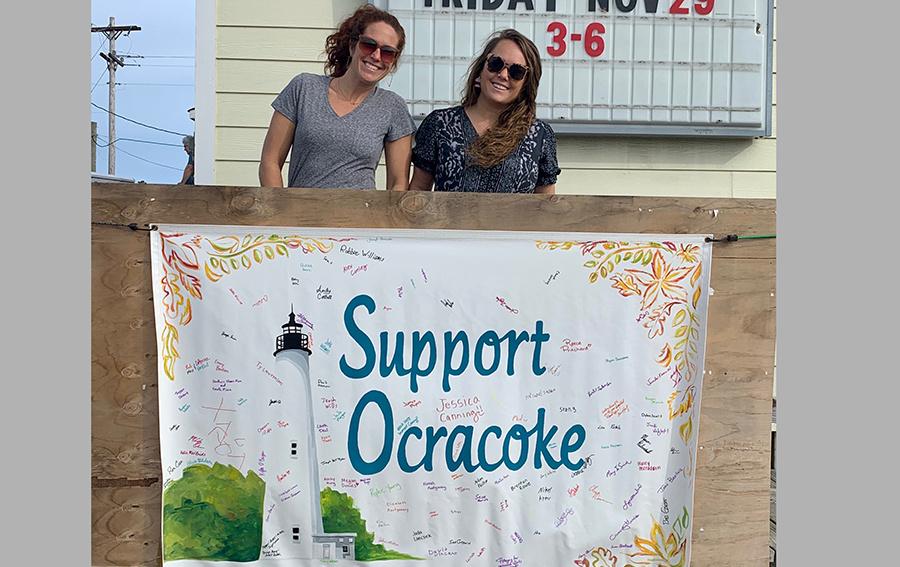 Art teachers Jenna Saunders (left) and Alice Baldwin (right) display the banner signed by First Flight students and teachers who donated to the cause. PHOTO SUBMITTED BY CHUCK LANSING