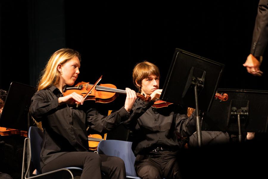 Senior Mary Kathryn Stroud (left) plays her violin while earning a spot in the all-region orchestra. Junior Heath Miller (right) focuses on his performance and earns a place in the all-region orchestra.