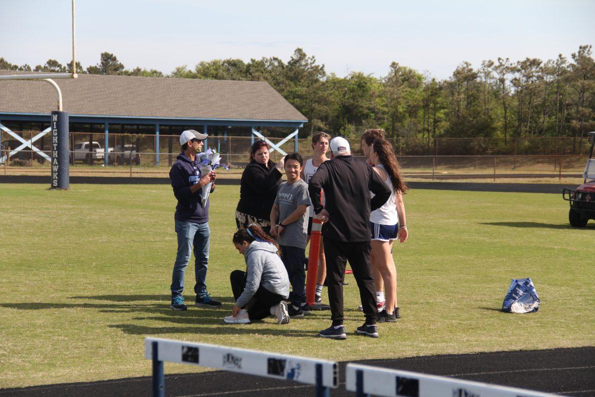 Track seniors stand with coaches Dan Murray and Gerry Piddington and Athletic Trainer Lindsay Austin. 